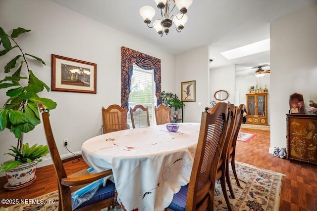 dining space with a skylight, a notable chandelier, and wood finished floors