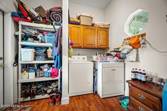 laundry area featuring cabinet space, wood finished floors, and washer and clothes dryer