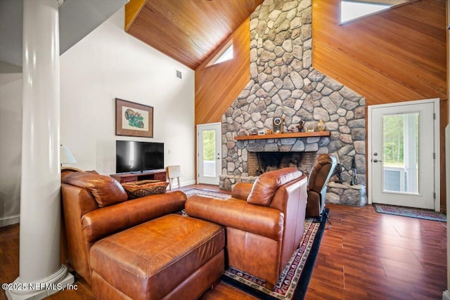 living area with wooden ceiling, high vaulted ceiling, a stone fireplace, visible vents, and ornate columns