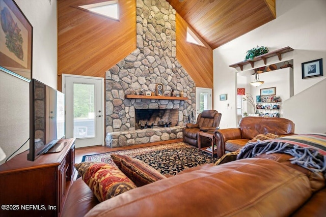 living area with high vaulted ceiling, wood finished floors, a fireplace, and wood ceiling