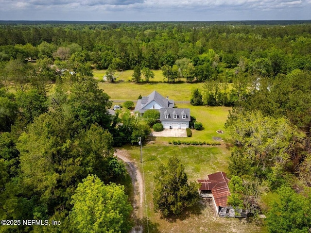 drone / aerial view with a wooded view