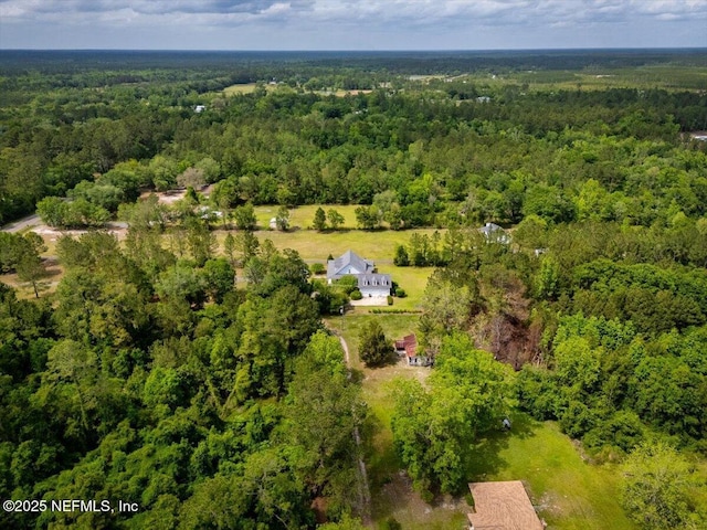 drone / aerial view featuring a wooded view