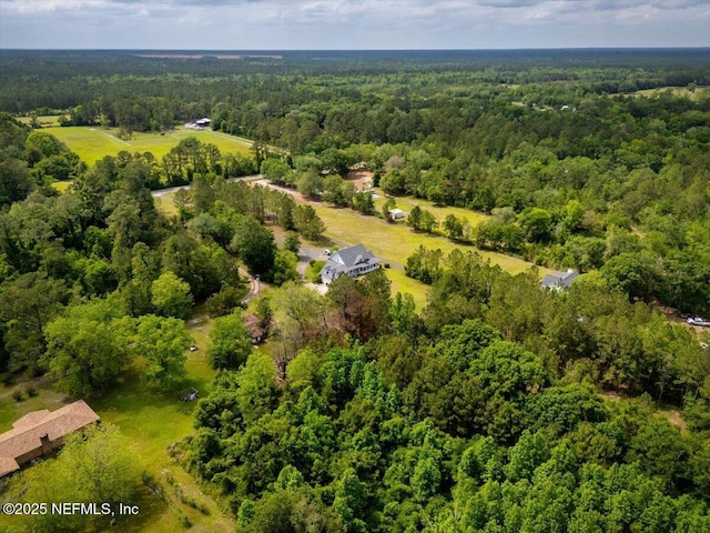 bird's eye view with a wooded view