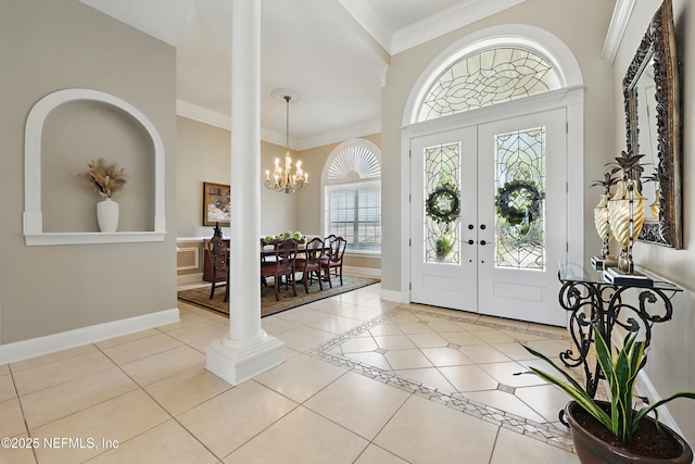 entrance foyer featuring ornamental molding, tile patterned flooring, a chandelier, and baseboards