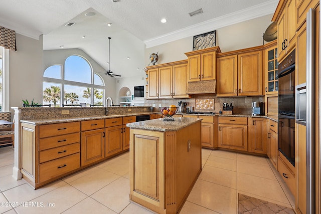 kitchen featuring tasteful backsplash, ceiling fan, visible vents, a peninsula, and brown cabinetry