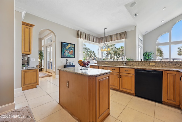 kitchen featuring light stone countertops, brown cabinets, black dishwasher, visible vents, and a kitchen island