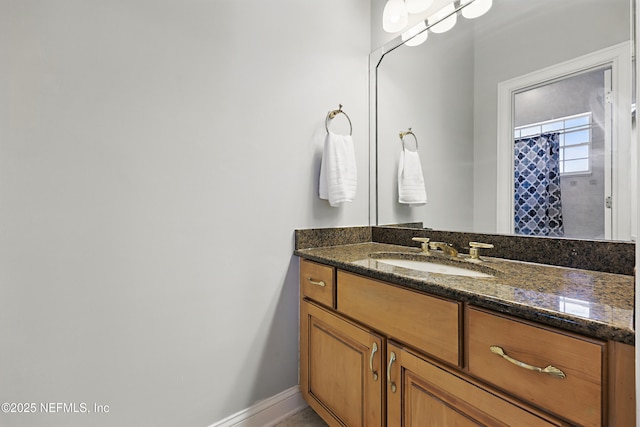 full bath featuring baseboards and vanity