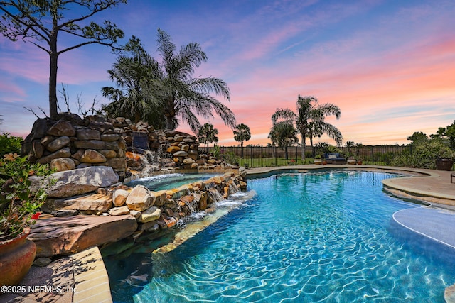 view of swimming pool featuring fence, an in ground hot tub, and a fenced in pool