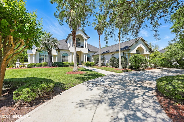mediterranean / spanish-style house with stucco siding and a front lawn