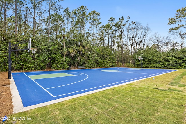 view of basketball court with a lawn and basketball hoop