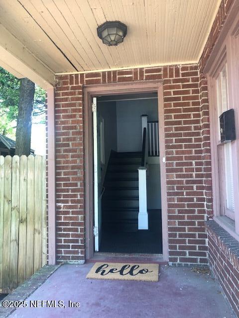 entrance to property featuring brick siding