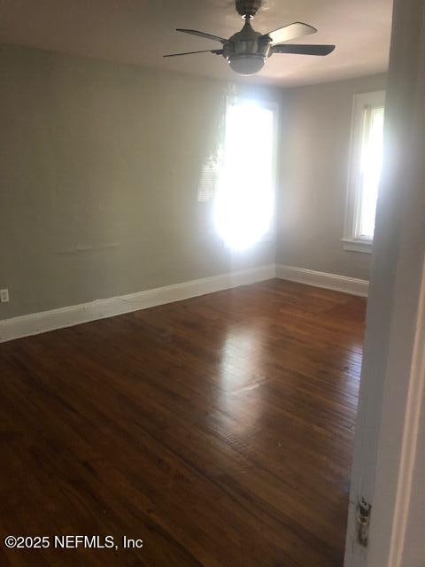 unfurnished room featuring baseboards, wood finished floors, and ceiling fan