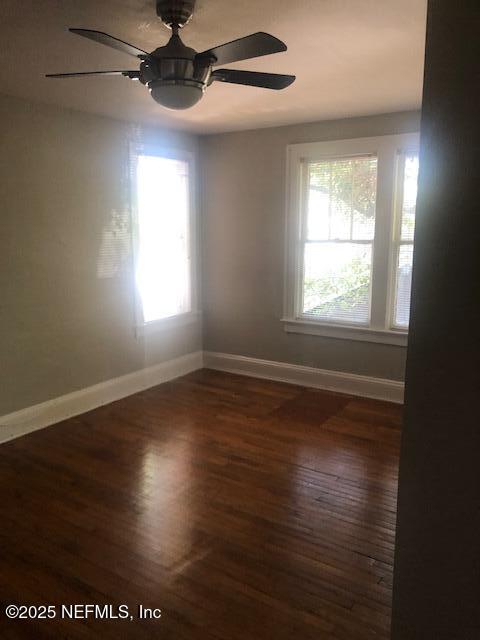 spare room with wood finished floors, baseboards, and ceiling fan