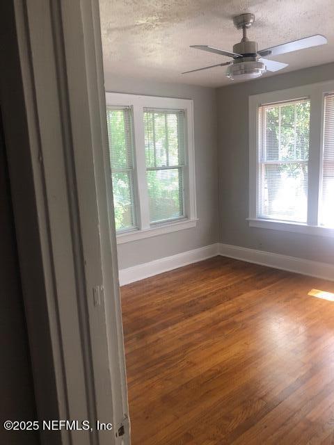 spare room featuring baseboards, a ceiling fan, and wood finished floors