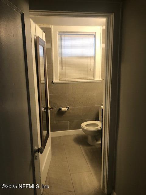 full bathroom featuring tile patterned floors and toilet