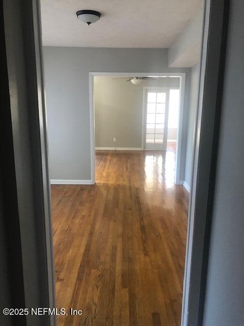 hall featuring baseboards and wood finished floors