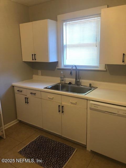 kitchen with white cabinets, dishwasher, light tile patterned floors, and a sink