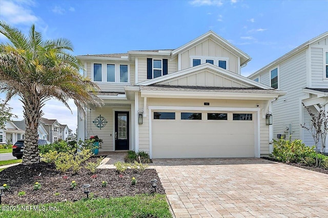 traditional-style home featuring board and batten siding, decorative driveway, and an attached garage