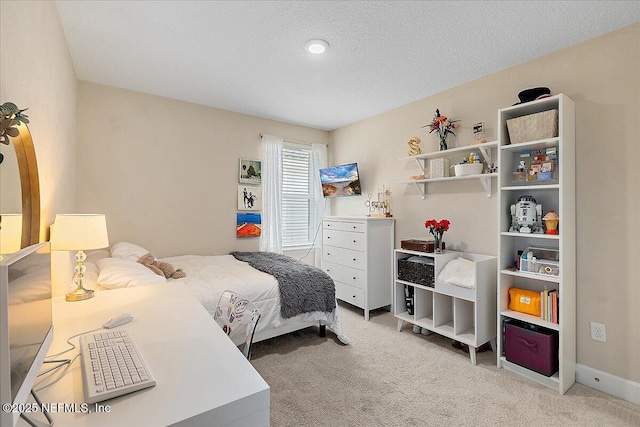 bedroom featuring a textured ceiling and light colored carpet