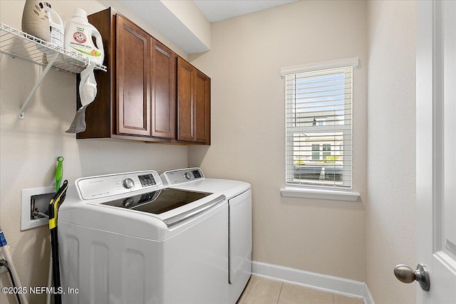 clothes washing area featuring cabinet space, separate washer and dryer, baseboards, and light tile patterned floors