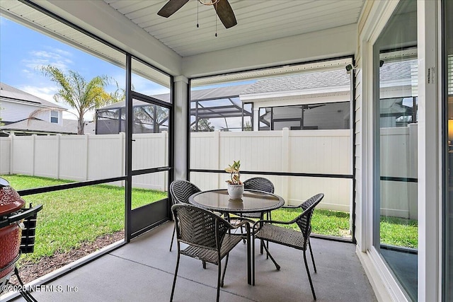 sunroom with a ceiling fan and outdoor dining area
