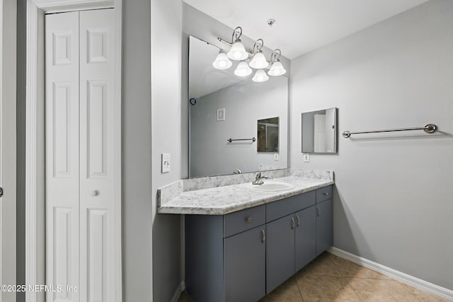 bathroom with baseboards, tile patterned floors, a closet, and vanity