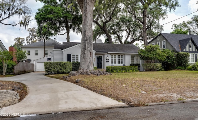 single story home with driveway, a garage, and fence