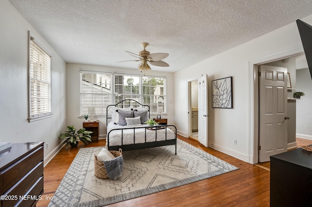 bedroom with a textured ceiling, wood finished floors, a ceiling fan, and baseboards