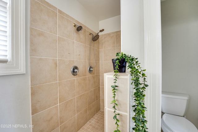 bathroom with toilet and a tile shower