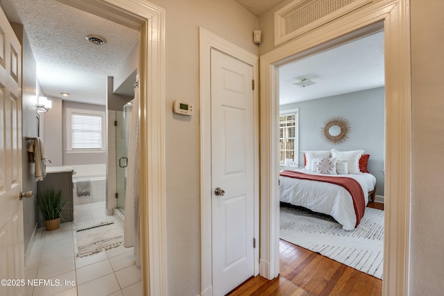 corridor featuring a textured ceiling and visible vents