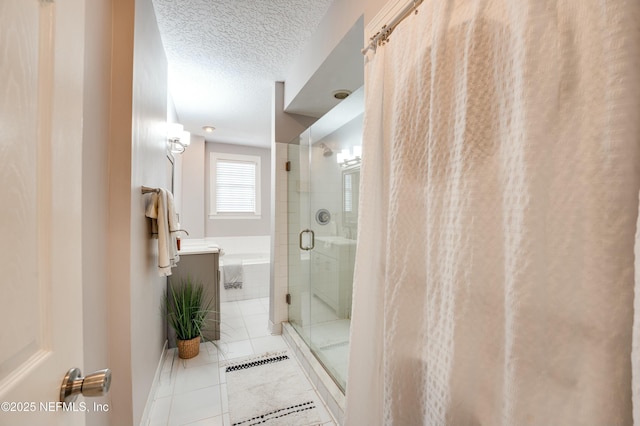 bathroom with a stall shower, a textured ceiling, and a bath