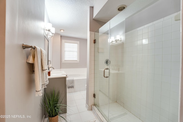 bathroom featuring a textured ceiling, a stall shower, a garden tub, vanity, and tile patterned flooring