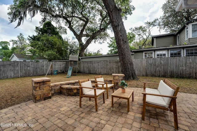view of patio / terrace with outdoor lounge area, a fenced backyard, and a playground