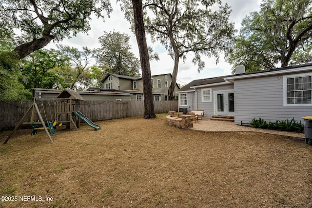 view of yard featuring a fenced backyard, a patio area, french doors, and a playground