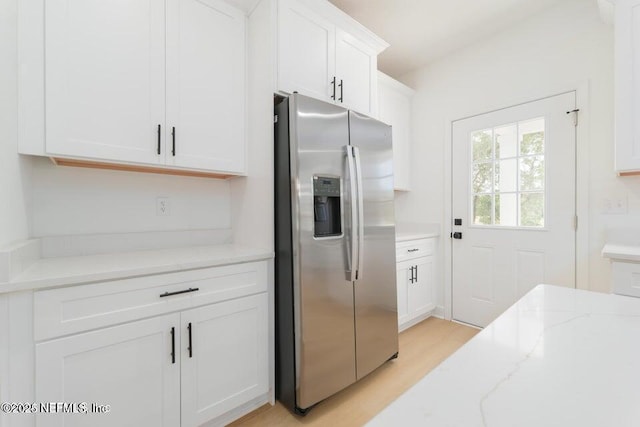 5817 Silver Sands Cir, Keystone Heights, FL 32656 - kitchen featuring white cabinets, stainless steel fridge with ice dispenser, light stone countertops, and light wood-style floors