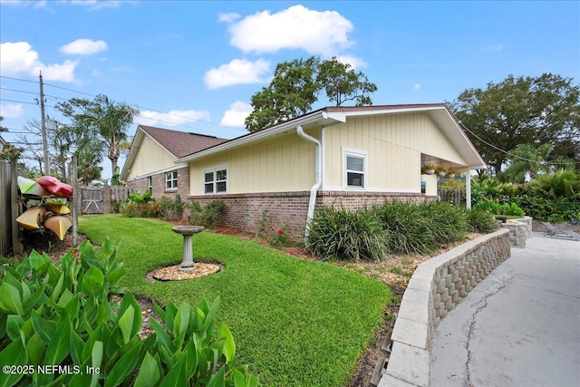4201 San Pablo Rd S, Jacksonville, FL 32224 - view of side of home featuring brick siding, a lawn, and fence