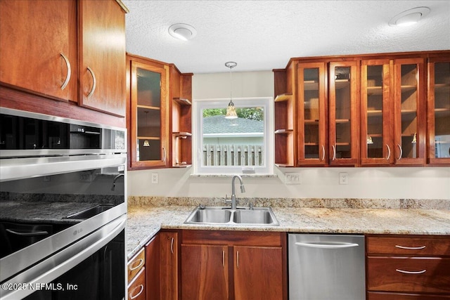 4201 San Pablo Rd S, Jacksonville, FL 32224 - kitchen featuring a textured ceiling, hanging light fixtures, a sink, glass insert cabinets, and stainless steel appliances
