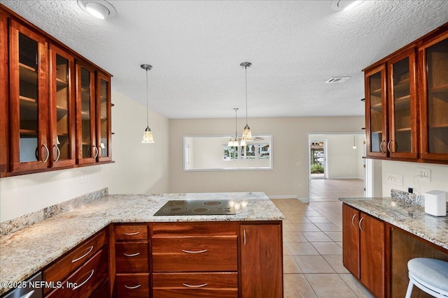 4201 San Pablo Rd S, Jacksonville, FL 32224 - kitchen with light stone counters, a peninsula, light tile patterned flooring, and black electric cooktop