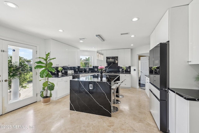 116 Lost Beach Ln, Ponte Vedra Beach, FL 32082 - kitchen featuring decorative backsplash, visible vents, dark countertops, black appliances, and recessed lighting