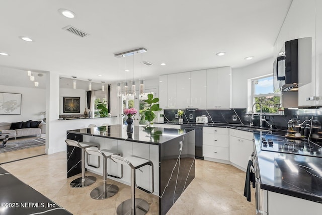 116 Lost Beach Ln, Ponte Vedra Beach, FL 32082 - kitchen with a kitchen breakfast bar, dark countertops, stainless steel electric stove, a sink, and dishwashing machine