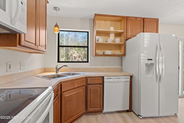 1625 Panther Ridge Ct, Jacksonville, FL 32225 - kitchen with a sink, white appliances, light wood-style flooring, pendant lighting, and a textured ceiling