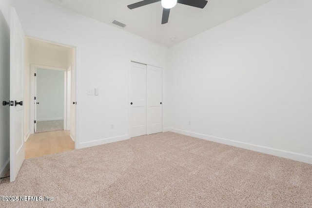 unfurnished bedroom featuring baseboards, visible vents, a ceiling fan, a closet, and carpet floors
