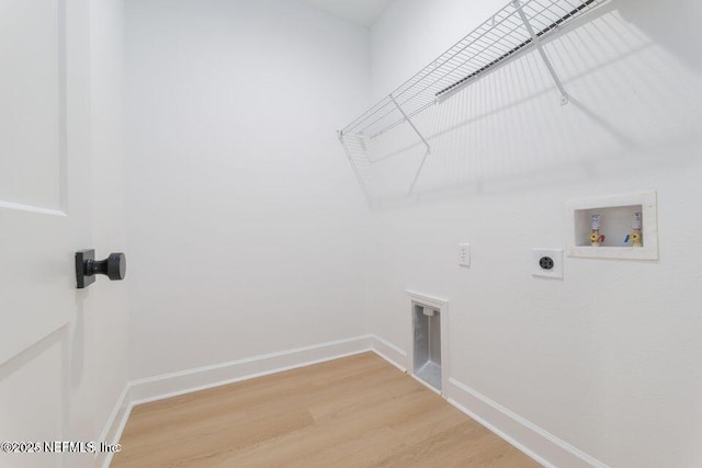 laundry area with laundry area, hookup for a washing machine, baseboards, electric dryer hookup, and light wood-style flooring