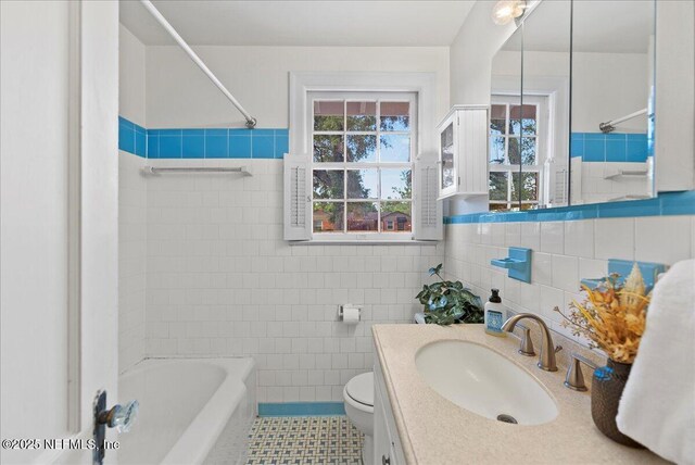 4379 San Jose Blvd, Jacksonville, FL 32207 - bathroom featuring tile walls, vanity, toilet, tile patterned floors, and bathtub / shower combination