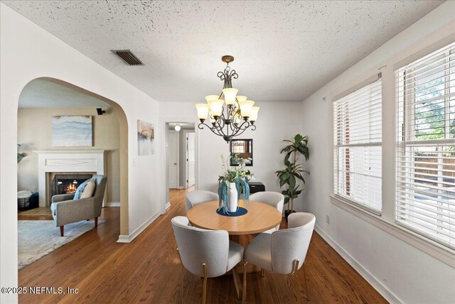 4379 San Jose Blvd, Jacksonville, FL 32207 - dining room with arched walkways, wood finished floors, a chandelier, baseboards, and a textured ceiling