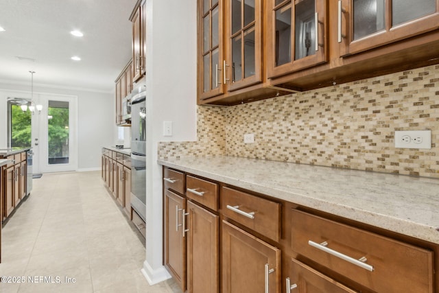 124 Sarah Elizabeth Dr, Saint Johns, FL 32259 - kitchen featuring crown molding, brown cabinetry, and light stone countertops