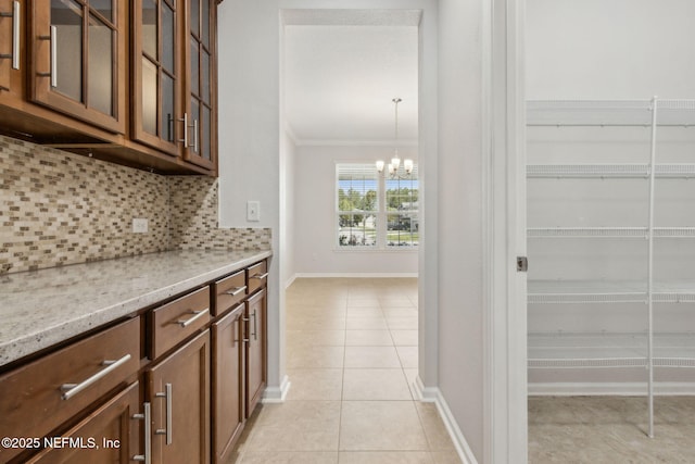 124 Sarah Elizabeth Dr, Saint Johns, FL 32259 - bar with an inviting chandelier, baseboards, decorative backsplash, light tile patterned flooring, and ornamental molding