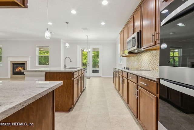 124 Sarah Elizabeth Dr, Saint Johns, FL 32259 - kitchen featuring baseboards, a glass covered fireplace, a sink, crown molding, and tasteful backsplash