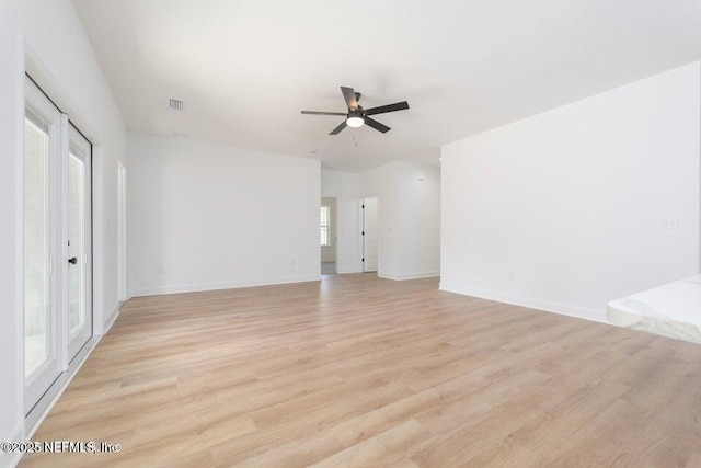unfurnished living room featuring baseboards, a ceiling fan, visible vents, and light wood-style flooring