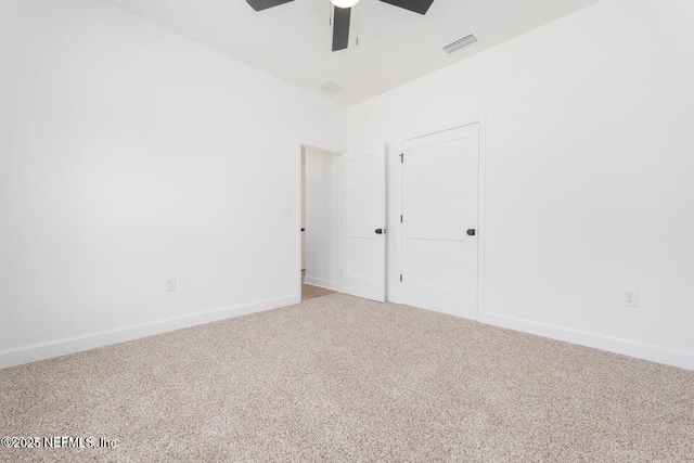 spare room featuring carpet, visible vents, baseboards, and ceiling fan
